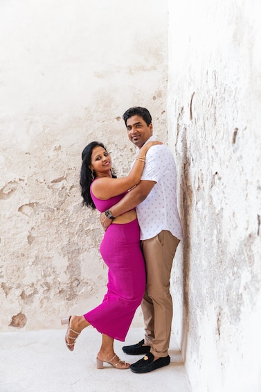A couple embracing in a narrow alleyway with rough, textured walls. 5