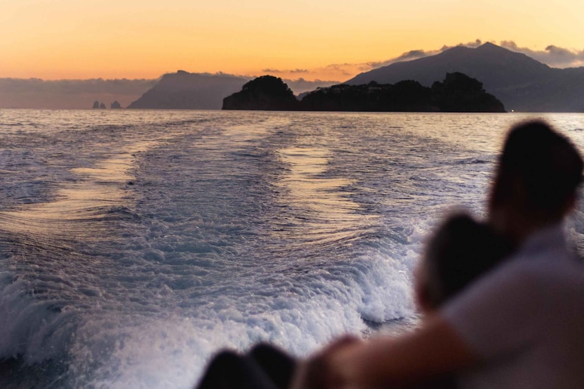 A person overlooking a body of water with waves and distant landforms. 3