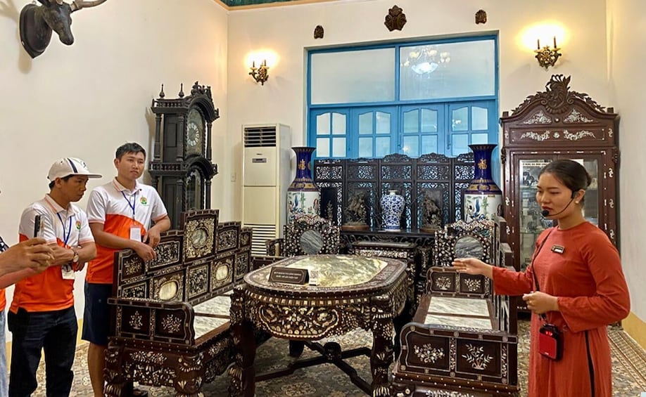 A room with ornate furniture, a large blue-framed window, and a clock on the wall. 2