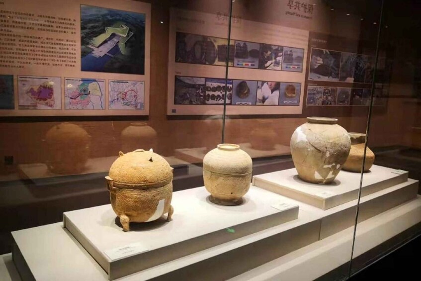 Three ancient pottery pieces on display in a museum. 2