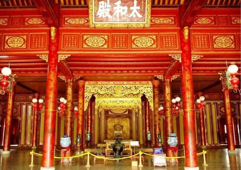 A traditional Chinese architectural structure with ornate red and gold decorations, large columns, and a central altar. 1
