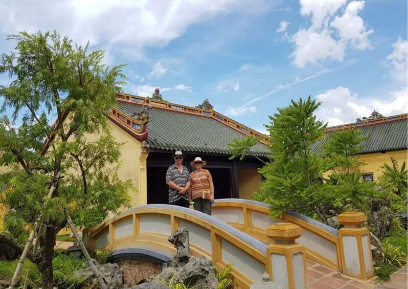 A traditional building with a curved roof, a stone bridge, and lush greenery. 4