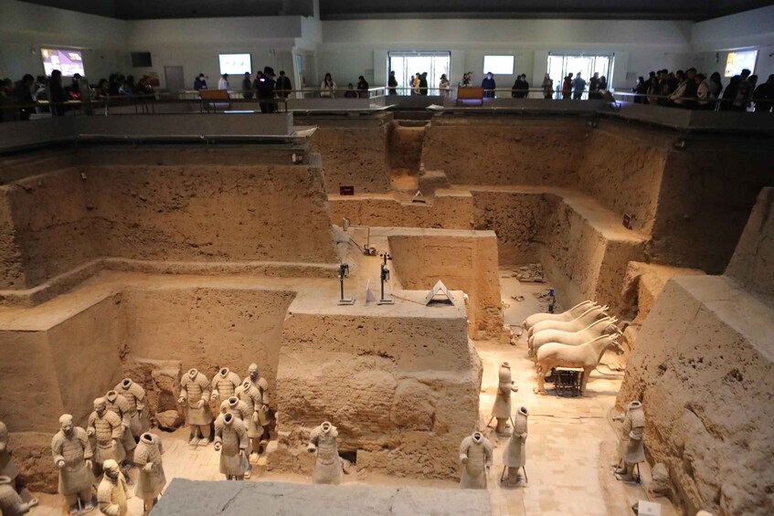 A museum exhibit with terracotta soldiers and horses. 3