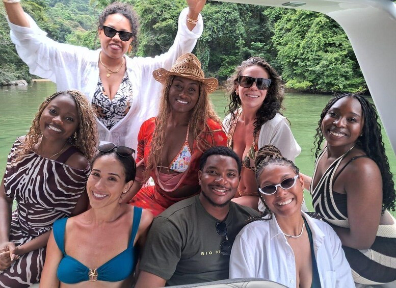A group of people on a boat surrounded by a forested river. 2