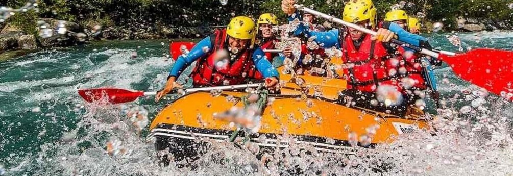A group of people in a raft navigating through a river with rapids. 1