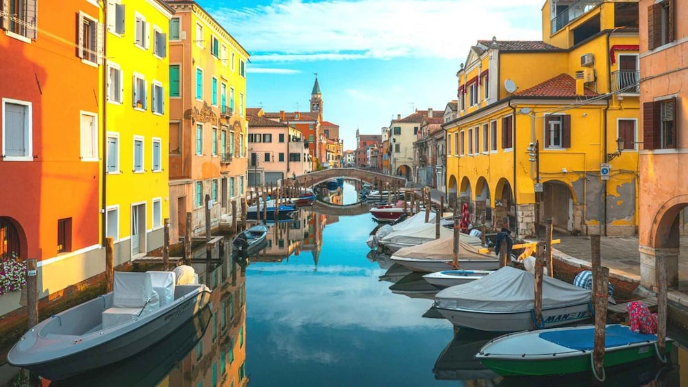 A canal with boats, colorful buildings, and a bridge. 2