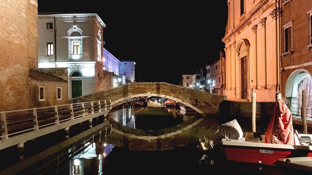 A stone bridge over a canal with buildings on either side. 3