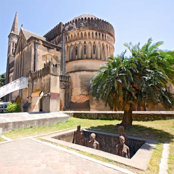 A historic church with a bell tower and a palm tree in the foreground. 1