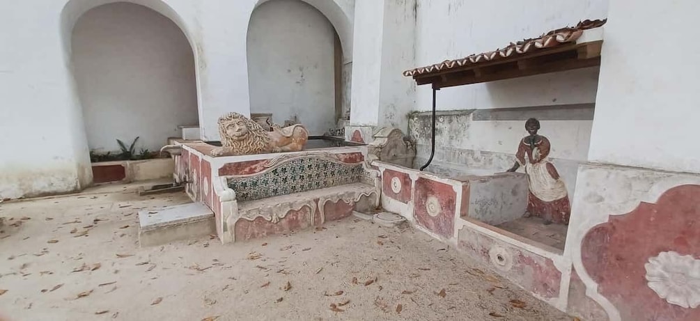 A courtyard with a fountain, a statue, and a tiled floor. 5