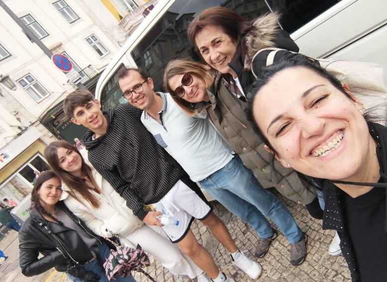 A group of people standing on a cobblestone street in front of a building with a blue and white sign. 1