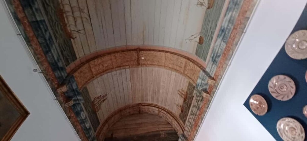 A spiral staircase with wooden steps and a decorative ceiling. 4