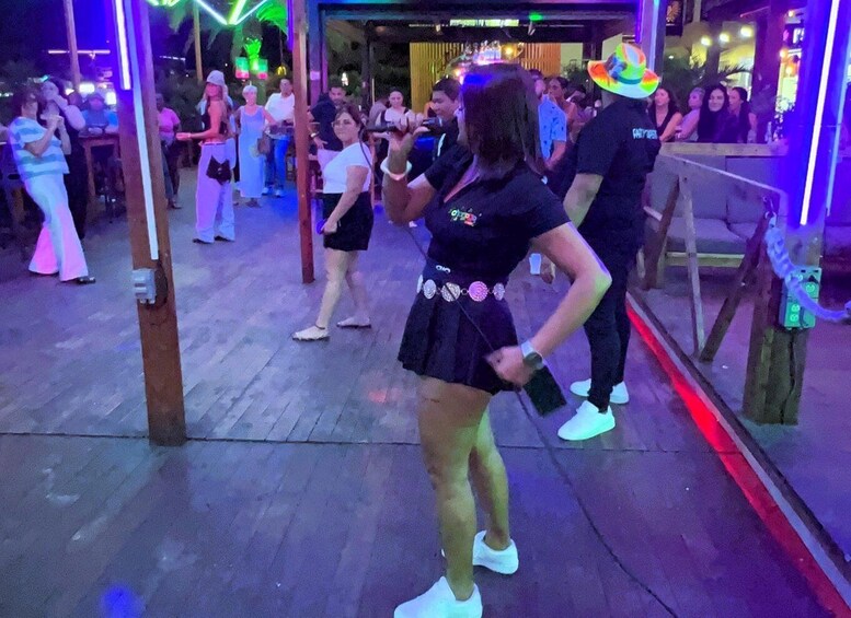 A group of people dancing at a lively event with colorful lighting. 3