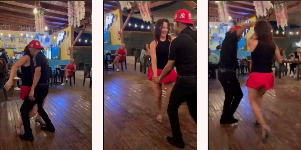 A couple dancing in a decorated indoor venue with wooden floors and hanging lights. 2