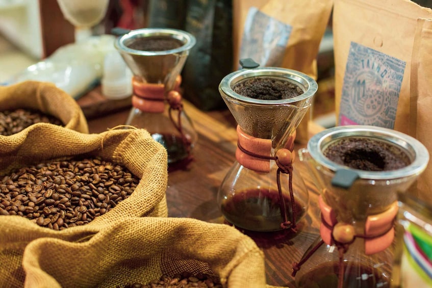 Coffee beans in burlap sacks and coffee grinders on a wooden table. 5