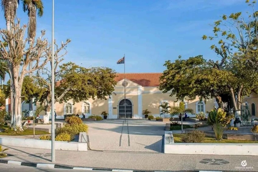 A building with a red roof, surrounded by trees and a flagpole. 3