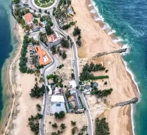 An aerial view of a coastal area with a beach, roads, and buildings. 2