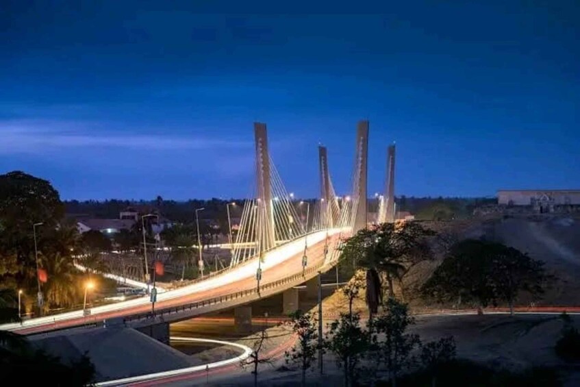 A bridge at dusk with illuminated cables and a lit roadway. 4