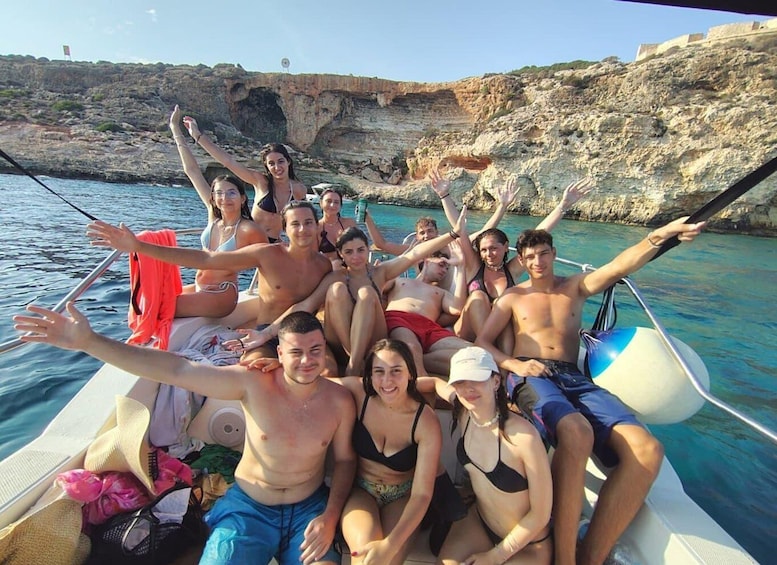 A group of people on a boat with rocky cliffs in the background. 2