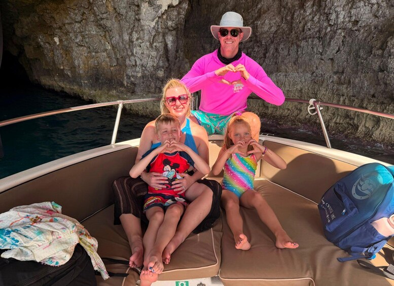 A family on a boat with rocky cliffs in the background. 5