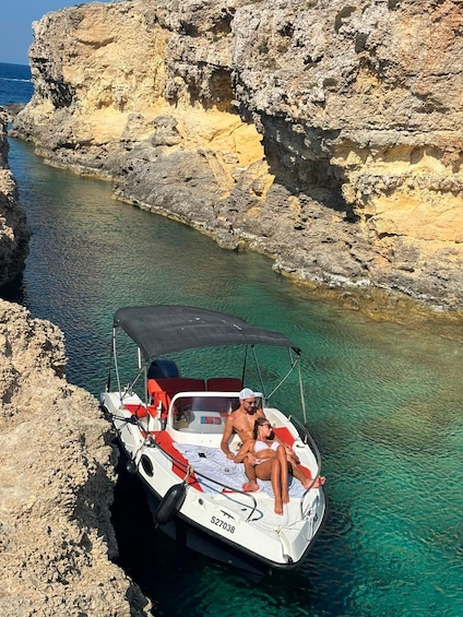 A boat with two people on a rocky coastline. 4