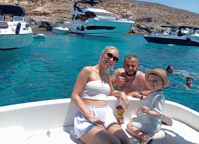 A family on a boat in a clear blue sea with rocky hills in the background. 3