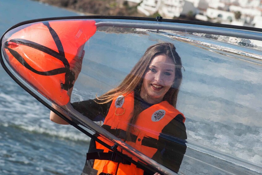 A person holding a red life jacket near a boat. 5