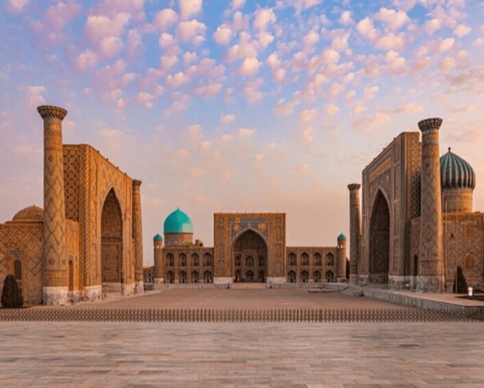 A historic building with domes and arches, a courtyard, and a clear sky. 2