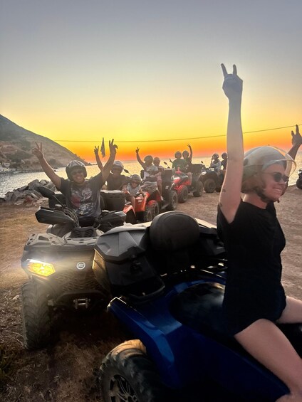 A group of people on ATVs at sunset with the ocean in the background. 5