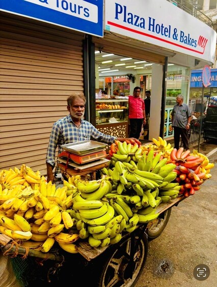 A street vendor selling bananas in front of a hotel. 2