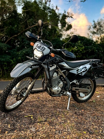 A motorcycle with the number 149 parked on a gravel surface. 1
