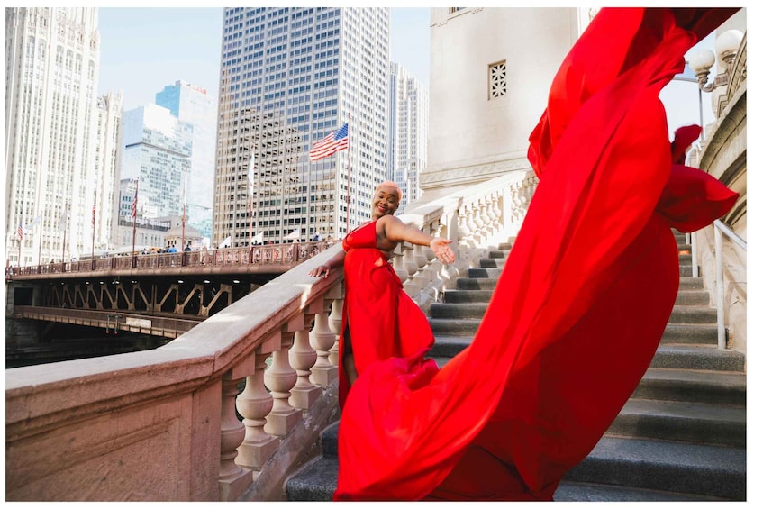 A person in a red dress standing on a bridge with a cityscape in the background. 5
