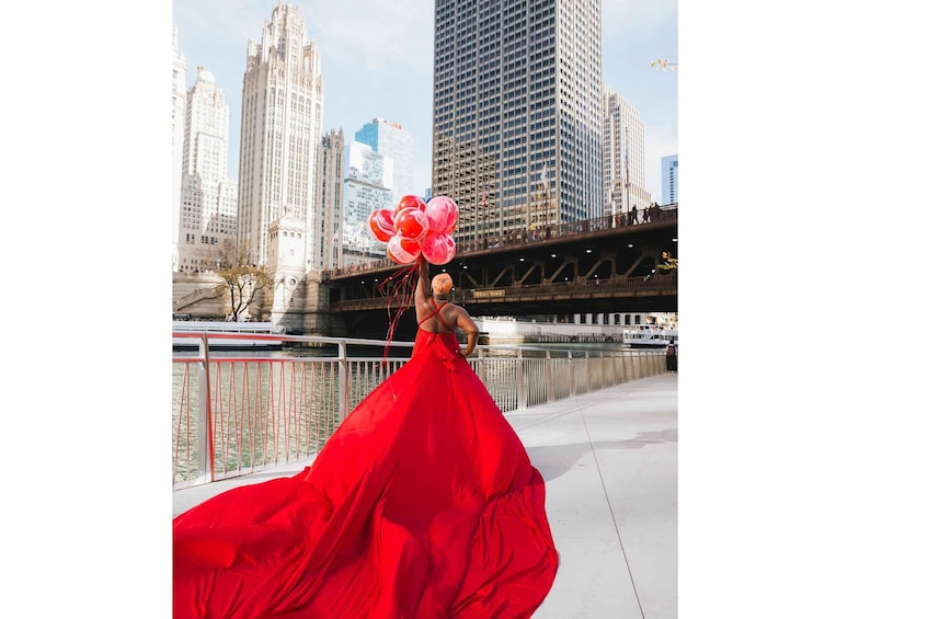 A person in a red dress holding balloons on a bridge with a cityscape in the background. 3