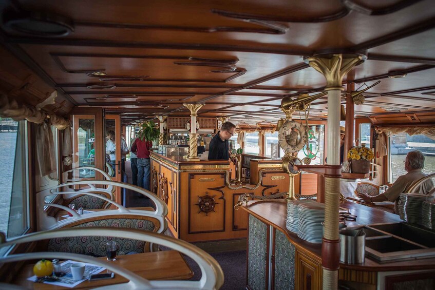 A bar area with wooden decor, a bartender, and tables with chairs. 3