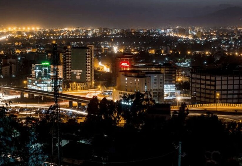 Une vue nocturne d’une ville, avec des bâtiments illuminés, une autoroute et un pont. 3