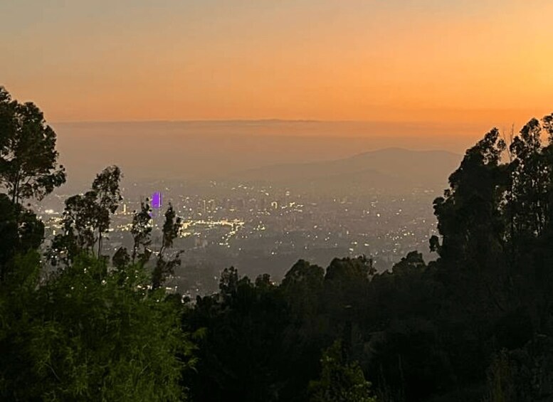 Une vue d’une ville au crépuscule, avec une chaîne de montagnes en arrière-plan. 2