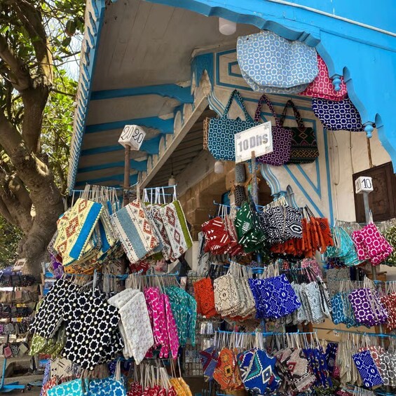 A variety of colorful bags displayed for sale at an outdoor market. 2