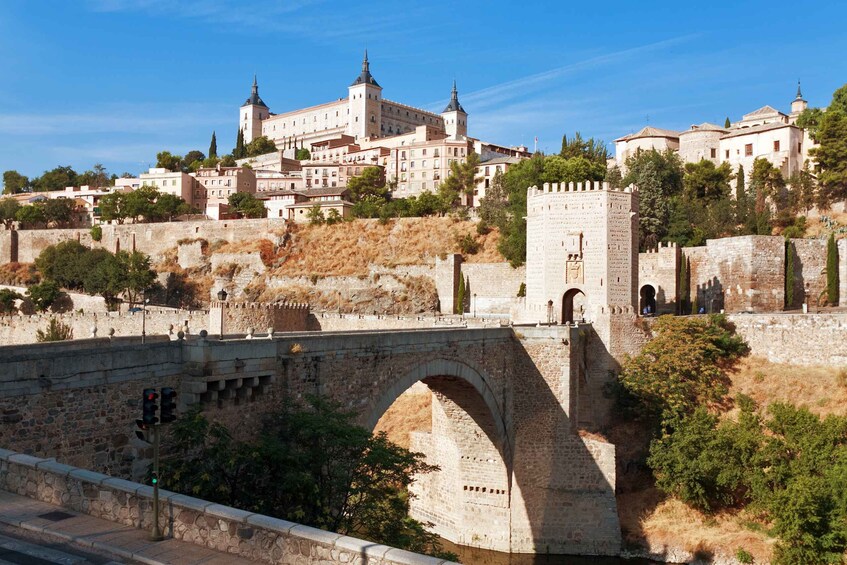 A stone bridge with an arch, a castle with towers, and a cityscape in the background. 2