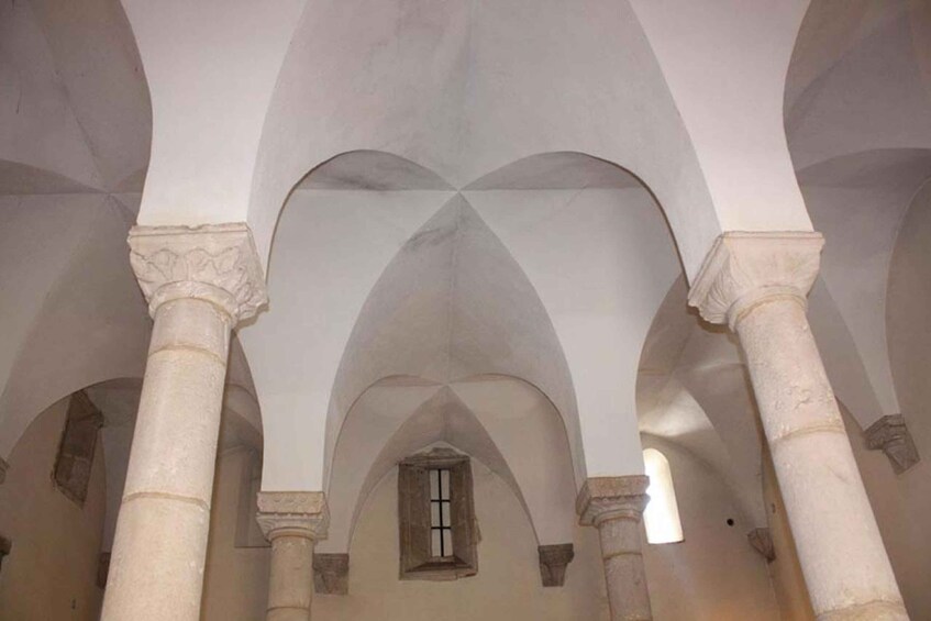 An interior with arched ceilings and columns. 2