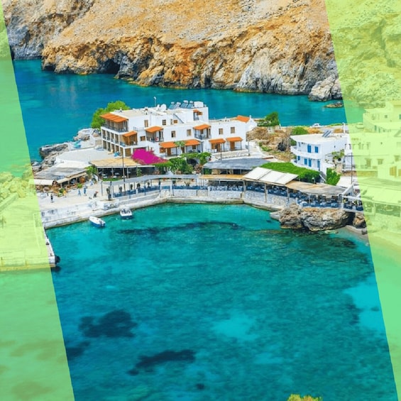 A coastal town with white buildings, a marina, and clear turquoise waters. 1