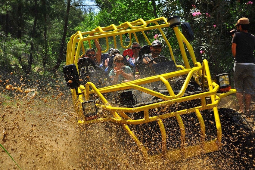 A yellow off-road vehicle driving through a forest, kicking up dust and leaves. 3