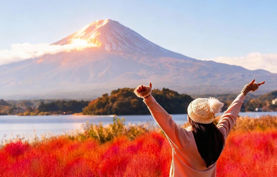 A person with arms raised facing a mountain. 1