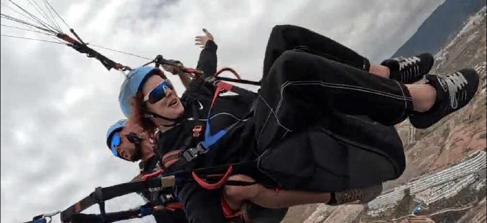 A person paragliding with a harness and parachute. 3