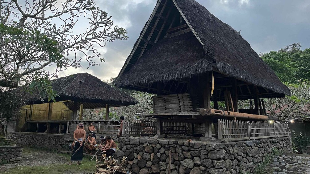 Traditional huts with thatched roofs, stone walls, and a stone staircase. 5