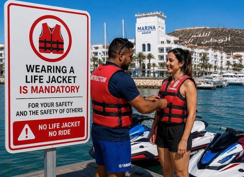 A life jacket sign and two people wearing life jackets by a marina. 3