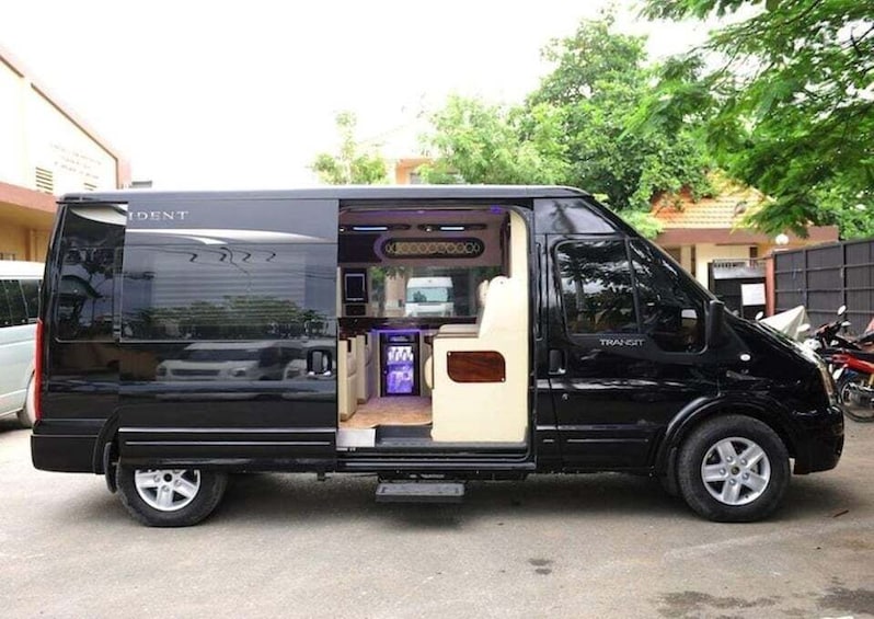 A black van with an open back, revealing a small kitchen area with a refrigerator and a sink. 4