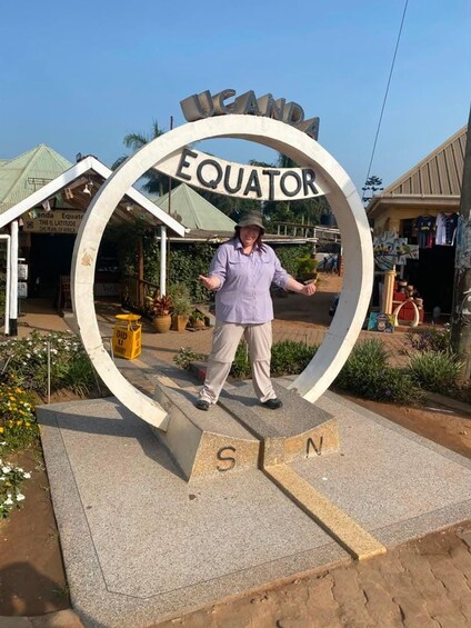 A person standing in front of a large sign with the words 'Equator' and 'S' and 'N' indicating the north and south poles. 4