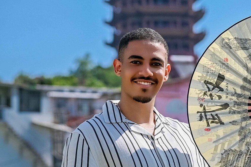 A person standing in front of a pagoda with traditional Chinese architecture. 5