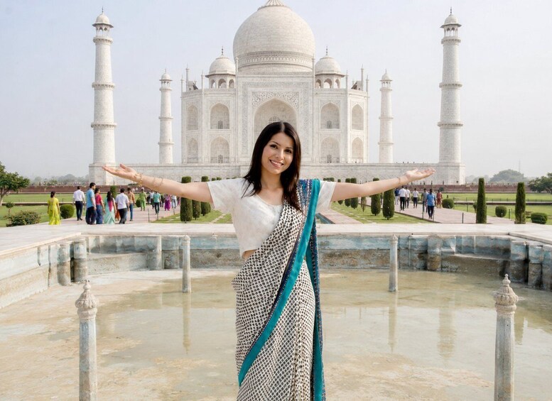 A person standing in front of the Taj Mahal with arms outstretched. 3