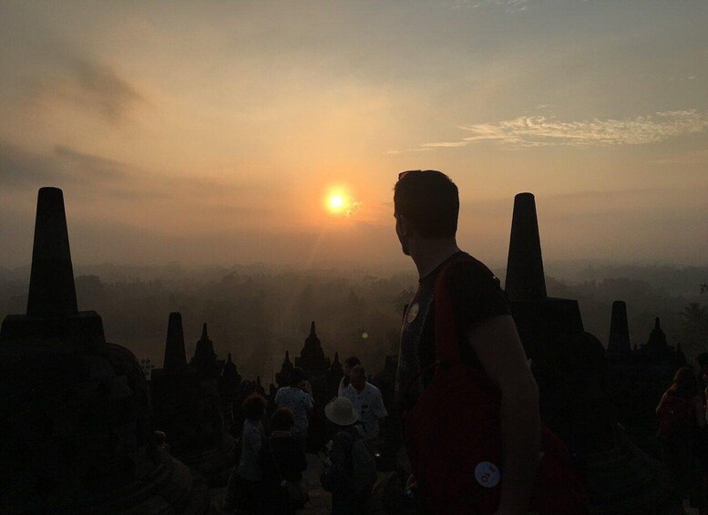A person standing with a sunset in the background. 5