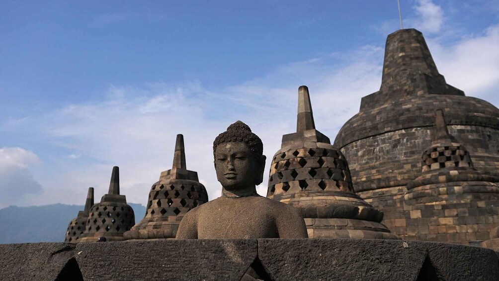 A Buddha statue in front of ancient stone structures. 2